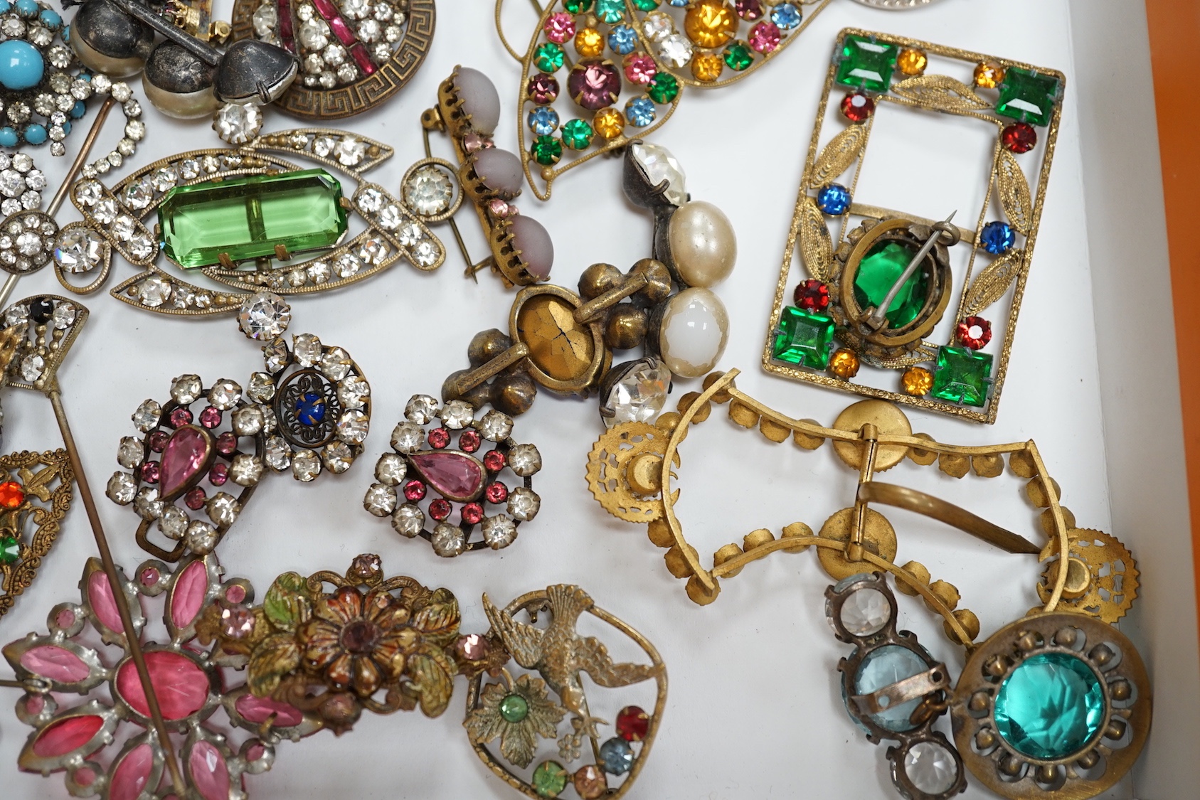 A quantity of assorted coloured and white paste jewellery, including brooches and buckles.